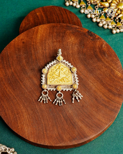 Enhance your style with the timeless elegance of the Dual Tone Silver Pendant. Handcrafted by skilled karigars in Barmer, Rajasthan, this neckpiece features traditional Bandhel work, where a thin sheet of hand beaten&nbsp;22 carat gold is set on 92.5 silver using a unique wax setting technique. A classic representation of fine Indian traditional craftsmanship.&nbsp;

Chain not included