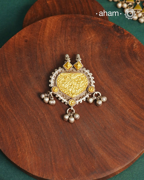 Enhance your style with the timeless elegance of the Dual Tone Silver Pendant. Handcrafted by skilled karigars in Barmer, Rajasthan, this neckpiece features traditional Bandhel work, where a thin sheet of hand beaten 22 carat gold is set on 92.5 silver using a unique wax setting technique. A classic representation of fine Indian traditional craftsmanship. 

Chain not included