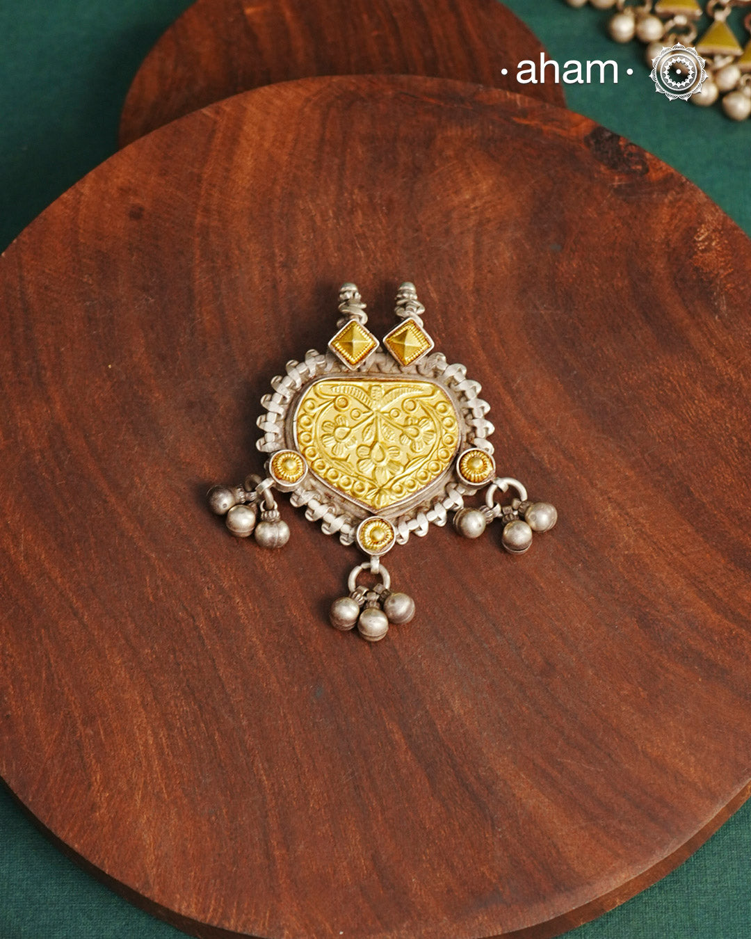 Enhance your style with the timeless elegance of the Dual Tone Silver Pendant. Handcrafted by skilled karigars in Barmer, Rajasthan, this neckpiece features traditional Bandhel work, where a thin sheet of hand beaten 22 carat gold is set on 92.5 silver using a unique wax setting technique. A classic representation of fine Indian traditional craftsmanship. 

Chain not included