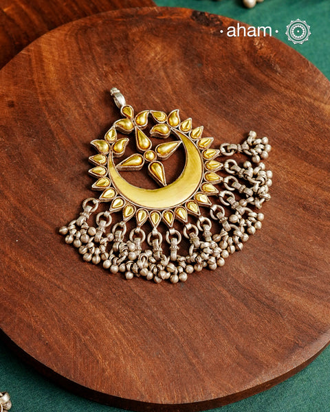 Enhance your style with the timeless elegance of the Dual Tone Silver Pendant. Handcrafted by skilled karigars in Barmer, Rajasthan, this neckpiece features traditional Bandhel work, where a thin sheet of hand beaten 22 carat gold is set on 92.5 silver using a unique wax setting technique. A classic representation of fine Indian traditional craftsmanship. 

Chain not included
