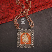 This Ganesha Hand Painted Silver Neckpiece is a true masterpiece, featuring a hand-painted Ganesha set in intricately crafted silver and adorned with stunning Kundan work and beautiful semi precious stone strings. Add an elegant touch of the divine to any outfit with this unique and eye-catching neckpiece.