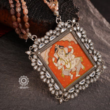 This Ganesha Hand Painted Silver Neckpiece is a true masterpiece, featuring a hand-painted Ganesha set in intricately crafted silver and adorned with stunning Kundan work and beautiful semi precious stone strings. Add an elegant touch of the divine to any outfit with this unique and eye-catching neckpiece.