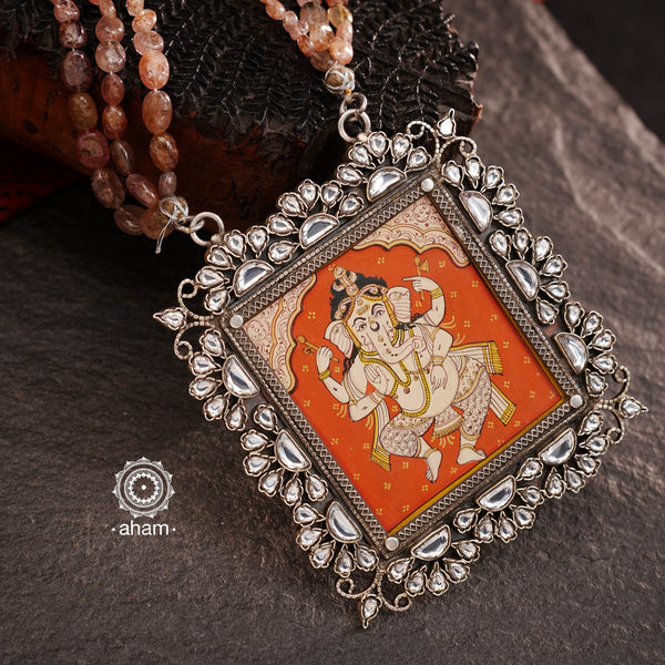 This Ganesha Hand Painted Silver Neckpiece is a true masterpiece, featuring a hand-painted Ganesha set in intricately crafted silver and adorned with stunning Kundan work and beautiful semi precious stone strings. Add an elegant touch of the divine to any outfit with this unique and eye-catching neckpiece.