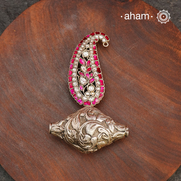 Enhance your style with the unique Ira Morpankh Silver Pendant. Featuring a stunning ambi kalki and chitai bead, this one-of-a-kind pendant can be worn with a chain or hasli, adding elegance to any outfit. Upgrade your look with this exquisite piece.(Does not include chain)
