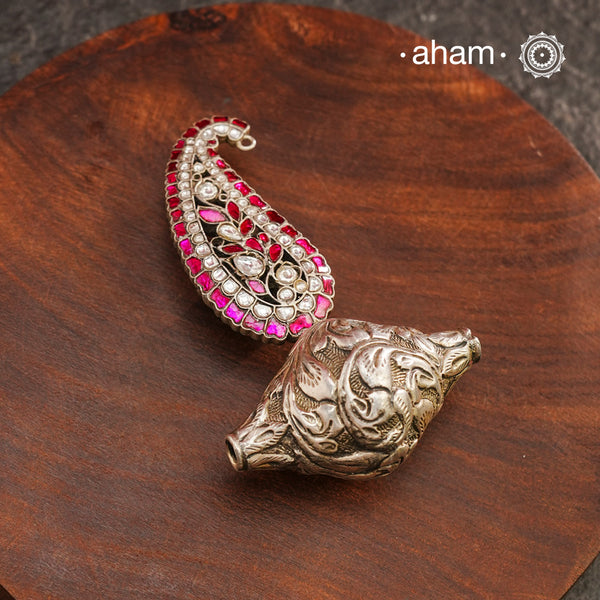 Enhance your style with the unique Ira Morpankh Silver Pendant. Featuring a stunning ambi kalki and chitai bead, this one-of-a-kind pendant can be worn with a chain or hasli, adding elegance to any outfit. Upgrade your look with this exquisite piece.(Does not include chain)