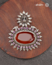 Peacock Silver pendant with a large carnelian stone center and kemp work on the sides.
A big bold pendant to make a statement. Wear it with a long chain or thread.&nbsp;
(Does not include chain)
