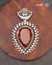 Silver Pendant with a large carnelian stone center and zircon stones around it.&nbsp;
A big bold pendant to make a statement. Wear it with a long chain or thread.&nbsp;

(Does not include chain)