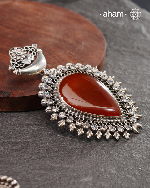 Silver Pendant with a large carnelian stone center and zircon stones around it.&nbsp;
A big bold pendant to make a statement. Wear it with a long chain or thread.&nbsp;

(Does not include chain)