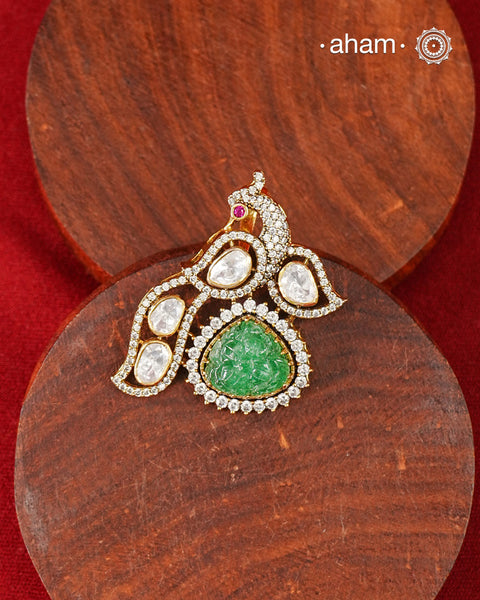 Inspired by the regal beauty of the peacock, this pendant is adorned with shimmering moissanite stones and highlighted by a textured green stone at its heart. Crafted in 92.5 silver and finished with gold polish, it reflects the charm of traditional artistry while remaining effortlessly wearable.
