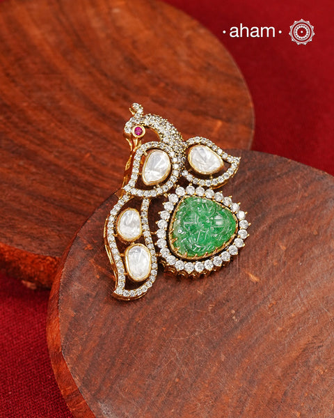 Inspired by the regal beauty of the peacock, this pendant is adorned with shimmering moissanite stones and highlighted by a textured green stone at its heart. Crafted in 92.5 silver and finished with gold polish, it reflects the charm of traditional artistry while remaining effortlessly wearable.