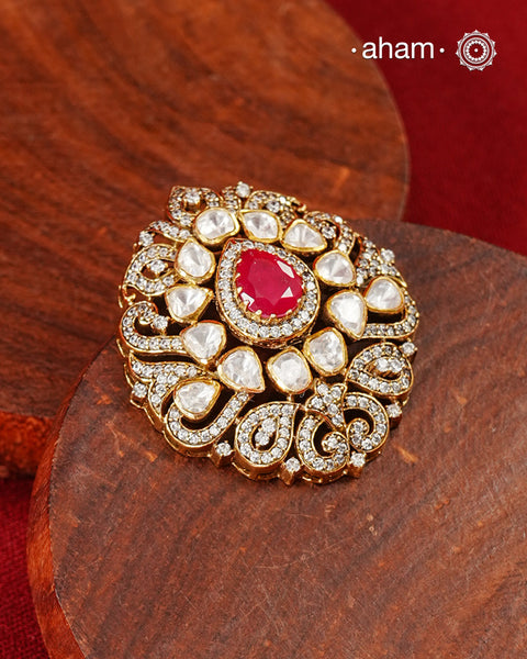 A celebration of classic craftsmanship, this pendant features a striking ruby-hued center stone framed by shimmering moissanites in an intricate floral design. Crafted in 92.5 silver and finished in gold polish, it is a versatile piece that effortlessly elevates festive, wedding, and occasion wear.