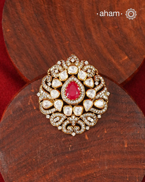 A celebration of classic craftsmanship, this pendant features a striking ruby-hued center stone framed by shimmering moissanites in an intricate floral design. Crafted in 92.5 silver and finished in gold polish, it is a versatile piece that effortlessly elevates festive, wedding, and occasion wear.
