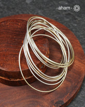 A cluster of plain silver bangles. These are so much fun to wear. gives the illusion of a stack. Crafted in 92.5 silver&nbsp;