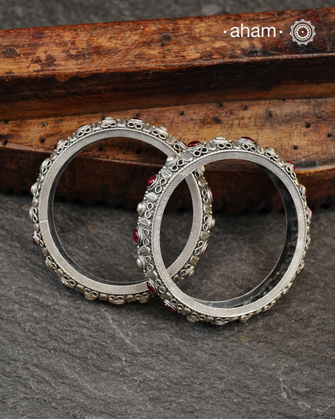 These handcrafted bangles showcases the exceptional skill of Kolhapur's master karigars, created entirely from 92.5 sterling silver with striking kemp stone accents.The bangle demonstrates superior craftsmanship through its precise construction and refined finish. Kemp highlights add textural depth and visual interest to the classic kada silhouette. An investment piece that honours traditional jewellery-making heritage while offering versatile styling for both formal occasions and daily adornment. 