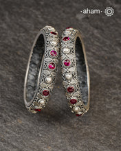 These handcrafted bangles showcases the exceptional skill of Kolhapur's master karigars, created entirely from 92.5 sterling silver with striking kemp stone accents.The bangle demonstrates superior craftsmanship through its precise construction and refined finish. Kemp highlights add textural depth and visual interest to the classic kada silhouette. An investment piece that honours traditional jewellery-making heritage while offering versatile styling for both formal occasions and daily adornment. 