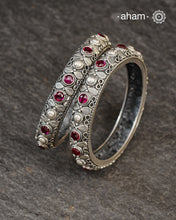 These handcrafted bangles showcases the exceptional skill of Kolhapur's master karigars, created entirely from 92.5 sterling silver with striking kemp stone accents.The bangle demonstrates superior craftsmanship through its precise construction and refined finish. Kemp highlights add textural depth and visual interest to the classic kada silhouette. An investment piece that honours traditional jewellery-making heritage while offering versatile styling for both formal occasions and daily adornment. 