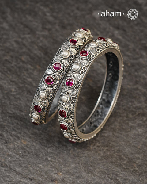 These handcrafted bangles showcases the exceptional skill of Kolhapur's master karigars, created entirely from 92.5 sterling silver with striking kemp stone accents.The bangle demonstrates superior craftsmanship through its precise construction and refined finish. Kemp highlights add textural depth and visual interest to the classic kada silhouette. An investment piece that honours traditional jewellery-making heritage while offering versatile styling for both formal occasions and daily adornment. 