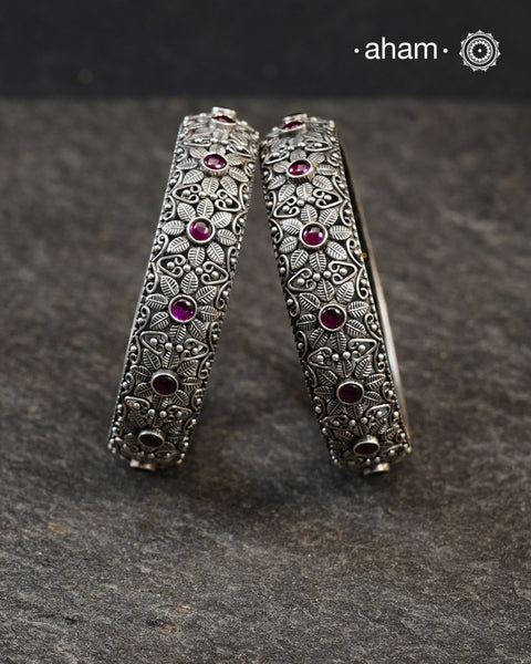 These handcrafted bangles showcases the exceptional skill of Kolhapur's master karigars, created entirely from 92.5 sterling silver with striking kemp stone accents.The bangle demonstrates superior craftsmanship through its precise construction and refined finish. Kemp highlights add textural depth and visual interest to the classic kada silhouette. An investment piece that honours traditional jewellery-making heritage while offering versatile styling for both formal occasions and daily adornment