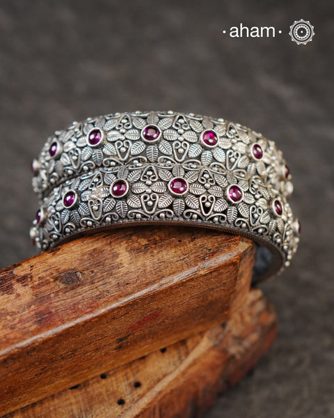 These handcrafted bangles showcases the exceptional skill of Kolhapur's master karigars, created entirely from 92.5 sterling silver with striking kemp stone accents.The bangle demonstrates superior craftsmanship through its precise construction and refined finish. Kemp highlights add textural depth and visual interest to the classic kada silhouette. An investment piece that honours traditional jewellery-making heritage while offering versatile styling for both formal occasions and daily adornment