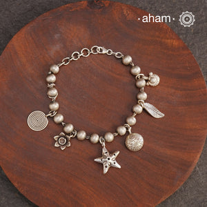 Up your wrist game with the A.M P.M Silver bracelet!
7 beautiful distinct charms all crafted in 92.5 silver come together to make this piece . Whether worn at day or night, this bracelet is Perfect for adding a playful touch to any outfit.

The price is for one piece only.