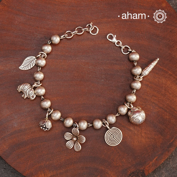 Up your wrist game with the A.M P.M Silver bracelet!
7 beautiful distinct charms all crafted in 92.5 silver come together to make this piece . Whether worn at day or night, this bracelet is Perfect for adding a playful touch to any outfit.