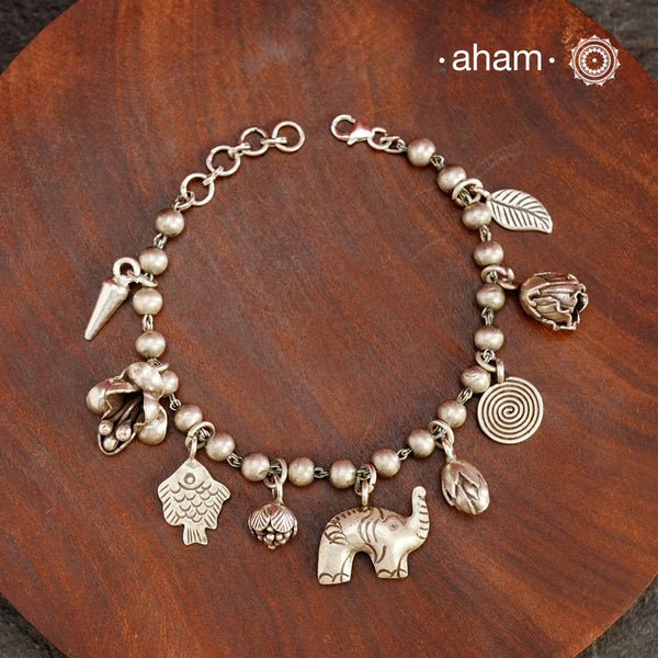 Up your wrist game with the A.M P.M Silver bracelet! 9 beautiful distinct charms all crafted in 92.5 silver come together to make this piece .Whether worn at day or night, this bracelet is Perfect for adding a playful touch to any outfit.