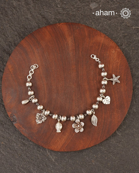 Up your wrist game with the A.M P.M Silver bracelet!
7 beautiful distinct charms all crafted in 92.5 silver come together to make this piece . Whether worn at day or night, this bracelet is Perfect for adding a playful touch to any outfit.

The price is for one piece only.