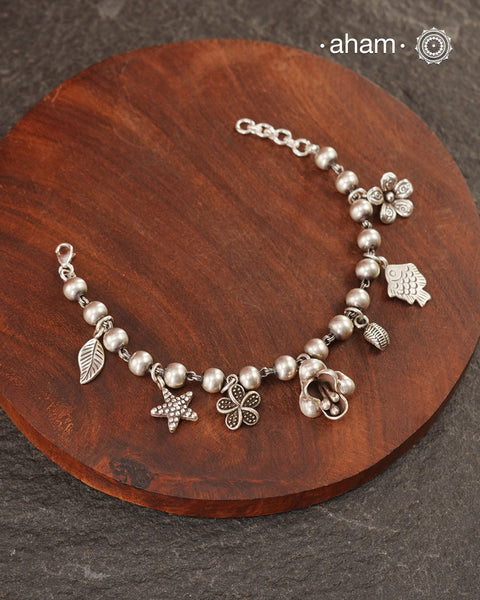 Up your wrist game with the A.M P.M Silver bracelet!
7 beautiful distinct charms all crafted in 92.5 silver come together to make this piece . Whether worn at day or night, this bracelet is Perfect for adding a playful touch to any outfit.

The price is for one piece only.