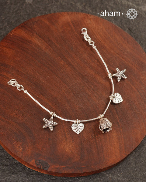Up your wrist game with the A.M P.M Silver bracelet!
Beautiful distinct charms all crafted in 92.5 silver come together to make this piece. the little bells make a rhythmic sound. Whether worn at day or night, this bracelet is Perfect for adding a playful touch to any outfit.

The price is for one piece only.