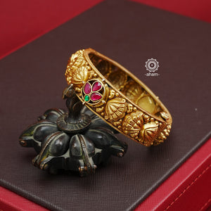 Enhance your traditional look with our Nakash Gold Polish Silver Kada. Crafted in silver with a stunning gold polish, the openable design features beautiful work and lotus motifs, accented with kemp flowers. Easy to wear and perfect for any occasion.  Price is for one piece only. 