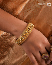 Expertly crafted in silver with a dazzling gold polish, this Intricate Gold Polish Silver Hand Kada is a true classic. Adorned with stunning tar work and kemp stone highlights, this timeless piece never goes out of style. Openable design adds convenience and versatility.The price is for one piece kada only.