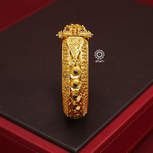 Expertly crafted in silver with a dazzling gold polish, this Intricate Gold Polish Silver Hand Kada is a true classic. Adorned with stunning tar work and kemp stone highlights, this timeless piece never goes out of style. Openable design adds convenience and versatility. The price is for one piece kada only.