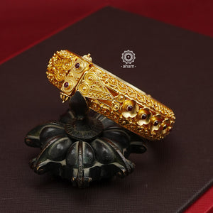 Expertly crafted in silver with a dazzling gold polish, this Intricate Gold Polish Silver Hand Kada is a true classic. Adorned with stunning tar work and kemp stone highlights, this timeless piece never goes out of style. Openable design adds convenience and versatility. The price is for one piece kada only.