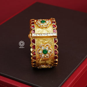 Crafted with expert precision, this Kundan Gold Polish Silver Kada showcases a stunning traditional design, also known as a patla in Gujarati. The kada features intricate Kundan highlights and is made of 92.5 silver with a lustrous gold polish. Perfect for adding a touch of elegance to any outfit. The price is for one piece kada only. 