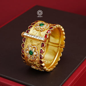 Crafted with expert precision, this Kundan Gold Polish Silver Kada showcases a stunning traditional design, also known as a patla in Gujarati. The kada features intricate Kundan highlights and is made of 92.5 silver with a lustrous gold polish. Perfect for adding a touch of elegance to any outfit. The price is for one piece kada only. 