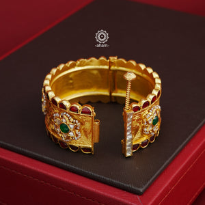 Crafted with expert precision, this Kundan Gold Polish Silver Kada showcases a stunning traditional design, also known as a patla in Gujarati. The kada features intricate Kundan highlights and is made of 92.5 silver with a lustrous gold polish. Perfect for adding a touch of elegance to any outfit. The price is for one piece kada only. 