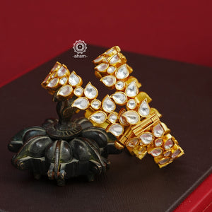 Add an elegant touch to your ethnic ensemble with our Kundan Gold Polish Silver Kada. Crafted in silver with a classic gold polish, these versatile Kadas are a must-have for weddings and special occasions. With the option to wear them alone or stacked, these Kadas are a versatile and timeless accessory.  The price is for a set of 2 pieces kada only. 