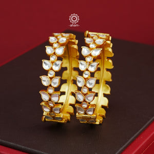 Add an elegant touch to your ethnic ensemble with our Kundan Gold Polish Silver Kada. Crafted in silver with a classic gold polish, these versatile Kadas are a must-have for weddings and special occasions. With the option to wear them alone or stacked, these Kadas are a versatile and timeless accessory.  The price is for a set of 2 pieces kada only. 