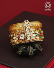 This openable Kundan Gold Polish Silver Kada gives the illusion of wearing two stacked kadas, with exquisite kundan work and laced pearls adding to its charm. Made with silver and finished in gold polish, it's a must-have for any jewellery collection.