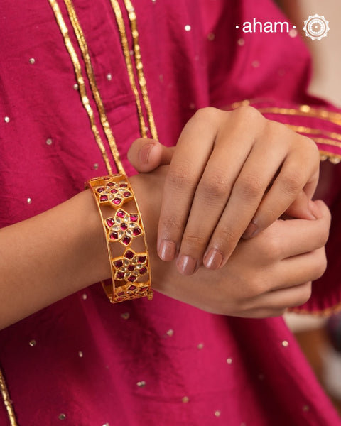 Elevate your style with our Flower Gold Polish Silver Kada. The beautiful openable design features exquisite kundan work crafted in silver and adorned with a luxurious gold polish. Perfect for adding a touch of elegance to any outfit.