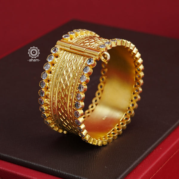 Looking for a gold toned accessory that works for both your Indian and western outfits? Then this is the perfect piece. Crafted in 92.5 silver with gold polish, this versatile kada is a must have addition to your wardrobe.  The price is for a One pieces kada only. 