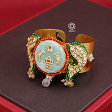 Elevate your jewellery game with our Gold Polish Hand Cuff with Kundan fish motifs. Its striking gold polish enhances the stunning stone inlay center and intricate kundan work. Versatile for both Indo-Western and traditional attire, this open cuff adds a stylish touch to any outfit.