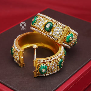 Elevate any outfit with our Kundan Gold Polish Silver Kada. Handcrafted with 92.5 sterling silver, this classic and versatile piece features green stone, mother of pearl, and pearl accents. Perfect for weddings and special occasions. Available in size 2.4 and openable design for easy wear.  The price is for 2 piece kada only.  Comes as a pair. 