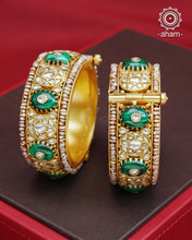 Elevate any outfit with our Kundan Gold Polish Silver Kada. Handcrafted with 92.5 sterling silver, this classic and versatile piece features green stone, mother of pearl, and pearl accents. Perfect for weddings and special occasions. Available in size 2.4 and openable design for easy wear.&nbsp;