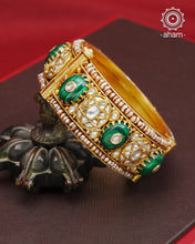 Elevate any outfit with our Kundan Gold Polish Silver Kada. Handcrafted with 92.5 sterling silver, this classic and versatile piece features green stone, mother of pearl, and pearl accents. Perfect for weddings and special occasions. Available in size 2.4 and openable design for easy wear.&nbsp;