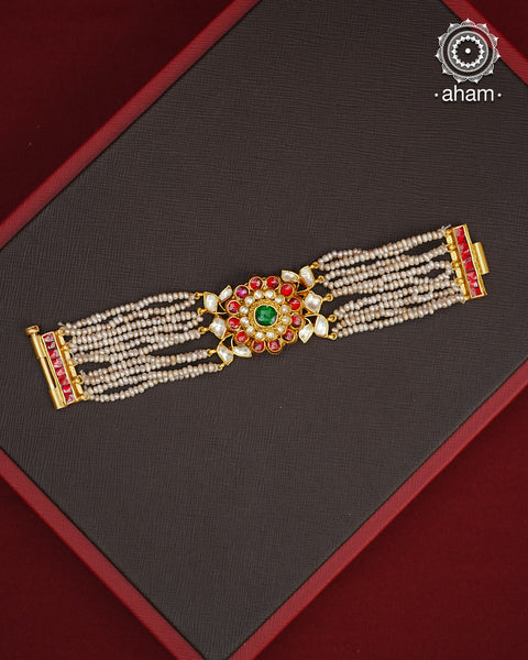 Expertly handcrafted with intricate Kundan work, this sterling silver Bracelet features a stunning gold polish and delicate pearl handwork. Perfect for any festive occasion, it adds a touch of elegance to any outfit. Elevate your style with this beautiful piece.