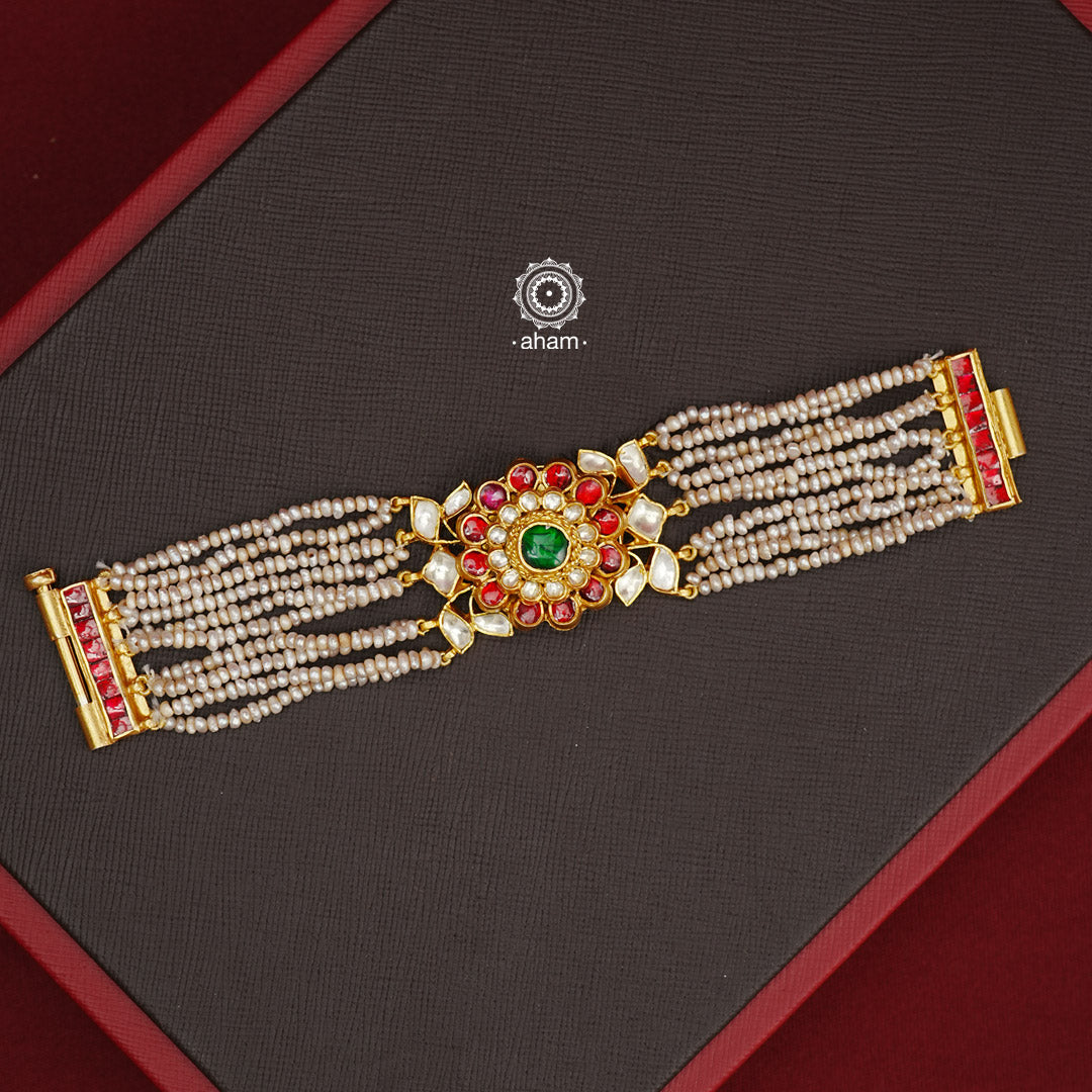 Expertly handcrafted with intricate Kundan work, this sterling silver Bracelet features a stunning gold polish and delicate pearl handwork. Perfect for any festive occasion, it adds a touch of elegance to any outfit. Elevate your style with this beautiful piece.