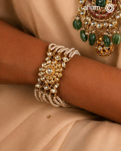 Expertly handcrafted with intricate Kundan work, this sterling silver Bracelet features a stunning gold polish and delicate pearl handwork. Perfect for any festive occasion, it adds a touch of elegance to any outfit. Elevate your style with this beautiful piece.