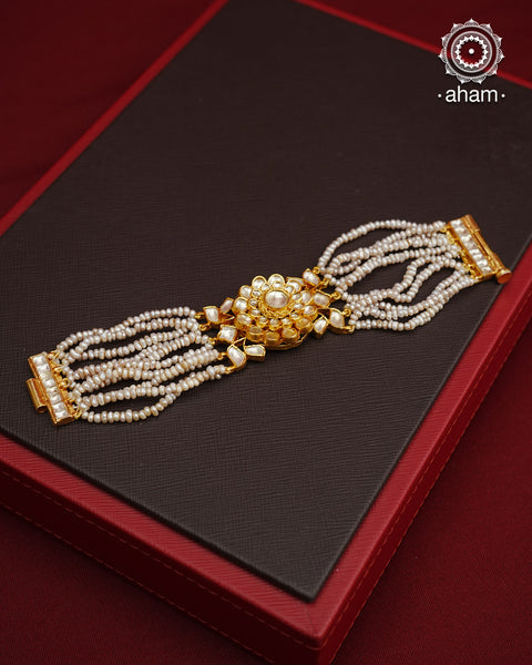 Expertly handcrafted with intricate Kundan work, this sterling silver Bracelet features a stunning gold polish and delicate pearl handwork. Perfect for any festive occasion, it adds a touch of elegance to any outfit. Elevate your style with this beautiful piece.