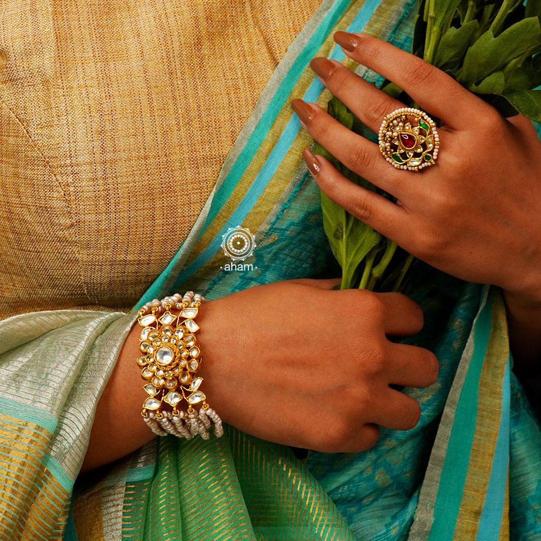 Expertly handcrafted with intricate Kundan work, this sterling silver Bracelet features a stunning gold polish and delicate pearl handwork. Perfect for any festive occasion, it adds a touch of elegance to any outfit. Elevate your style with this beautiful piece.